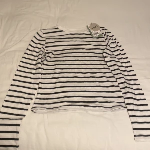 Randig långärmad tröja från HM - Säljer en svart- och vitrandig tröja från HM! Tröjan är långärmad och sitter åt det tajtare hållet! Tröjan kom i ett två-pack med en svart också, man har aldrig fått användning för den randiga! Har aldrig använt den förutom när jag prövade den och säljer den till hälften av priset som båda tröjor kostade sammanlagt! Skriv för fler bilder och pris kan diskuteras vid snabbt köp! 🩷