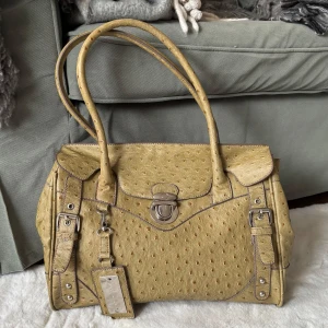 Grön handvösna - Snygg grön-beige handväska med ett unikt strutsliknande läder. Köpt för länge sen i en vintage butik men har själv aldrig fått användning av den så säljer den nu till någon som kan få bättre användning av den🩷🤗