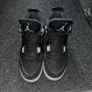 Svarta Nike Air Jordans - Säljer ett par begagnade svarta Nike Air Jordans med klassisk design. Skorna har snörning och en synlig Air-enhet i sulan för extra komfort. De har vita och grå detaljer samt den ikoniska Jumpman-loggan på tungan och hälen. Hojta om ni är intresserade eller vill se fler bilder