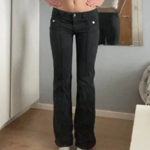 Svarta byxor från H&M - Snygga svarta byxor från H&M med en klassisk design. Byxorna har en rak passform och är perfekta för en stilren look. De har knappar framtill och är tillverkade i ett bekvämt material.