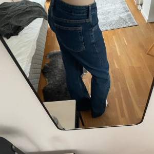 Lågmidjade jeans - Säljer dessa snygga mörkblå jeans med låg midja och rak passform från Bikbok. Har en superfin blå färg, sparsamt använda. Ger en snygg baggy look, storlek 26/32. Hör av er om frågor💕