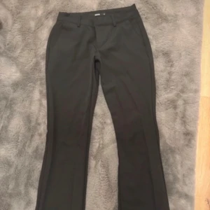 Svarta kostymbyxor från BikBok - Snygga svarta kostymbyxor från BikBok i storlek 34. Byxorna har en klassisk design med raka ben och en stilren look. Perfekta för en chic och professionell stil. Midwaist 