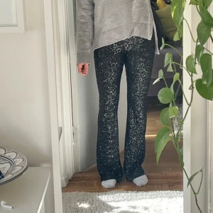 Svarta paljettbyxor från Zara - Snygga svarta byxor från Zara täckta med glittriga paljetter. Perfekta för att sticka ut på festen. Byxorna har en tight passform och är högmidjade för en smickrande siluett.