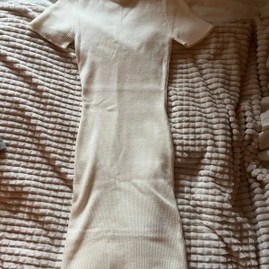 Beige ribbstickad klänning - Snygg beige ribbad klänning med korta ärmar och en tight passform. Passar både S/XS