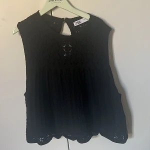 Svart ärmlös topp från Zara - Säljer en elegant svart ärmlös topp från Zara med vackra spetsdetaljer. 🖤storlek M men passar mig som har storleken S