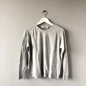Grå tröja från Hope - Säljer en stilren grå tröja från Hope i 100% bomull. Tröjan har en klassisk rund halsringning och långa ärmar. I bra skick. 