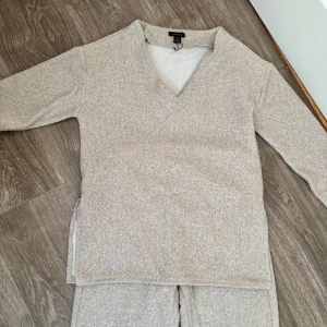 Beige ribbade mjukisbyxor från Missu - Supermysiga beige mjukisbyxor från Missu med ribbad struktur och resår i midjan. Byxorna har en relaxed fit och är perfekta för chill dagar hemma. Fickor på sidorna och mjukt material som känns skönt mot huden.