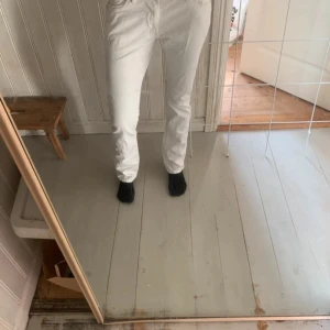 Vita raka jeans från Gant - Säljer ett par fräscha vita jeans från Gant med klassisk femficksdesign och raka ben. Byxorna har normal passform och är tillverkade i bomull för en skön känsla. Perfekta för dig som gillar stilrena och ljusa plagg.
