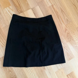 Svart kortkjol från Chiquelle XS - Enkel och stilren svart kortkjol från Chiquelle i storlek XS. Kjolen har en rak passform och är tillverkad i ett slätt tyg. Perfekt att matcha med en crop top eller stickad tröja för en clean look.( har ing bilder med kjolen på)