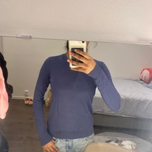 Blå stickad tröja från 157, XS - En basic blå stickad tröja från Lager 157 i storlek XS. Tröjan har rund halsringning, ribbade muddar och är långärmad. Perfekt att slänga på sig till jeans eller kjol för en chill look. Materialet känns mjukt och lätt.