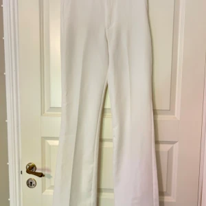 Vita wide kostymbyxor från BikBok - Snygga vita kostymbyxor från BikBok i storlek 36.  Hög midja, vida ben och bälteshällor. Perfekta för en clean och stilren look. Materialet  är väldigt mjukt och skönt att bära 🌸✨