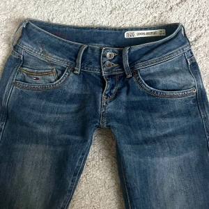 Lågmidjade bootcut jeans - Säljer lågmidjade utsvängda Jeans från Tommy Hilfiger som tyvärr är för små för mig! 😫De är i storlek W29 L30 men är mycket mindre i storlek! Skulle säga att de passar XS/S.                                                  Midja: 36cm Innerbenslängd: 76cm               Bra skick förutom att jeanslappen är lite sönder (se sista bild)