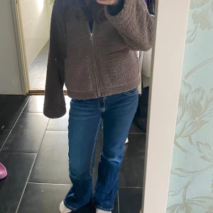 Blå bootcut jeans Gina Tricot 164 - Snygga blå jeans från Gina Tricot i storlek 164. Modellen har bootcut-ben, klassisk femficksdesign och coola detaljer på bakfickorna. Jeansen är i denim med ljusa slitningar för en trendig look.