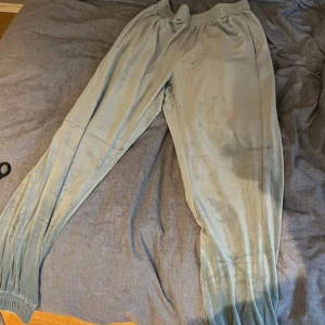 Ljusblå mjukisbyxor från Hunkemöller - Supermjuka ljusblå mjukisbyxor från Hunkemöller i sammet. Byxorna har resår i midjan och vid bensluten, samt fickor på sidorna. Perfekta för chill eller mysiga dagar hemma. Snygg och avslappnad passform.