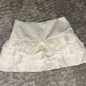 Vit volangkjol Zara - Supersöt vit kortkjol från Zara med inbyggda shorts under. Såå snygg!! Ge prisförslag!