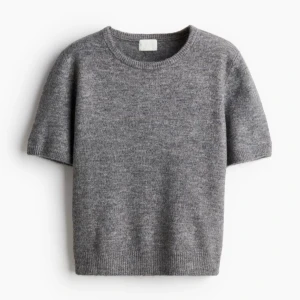 Stickad kortärmad tröja  - En stilren grå stickad tröja med korta ärmar och rund halsringning. Perfekt för lager-på-lager och funkar lika bra till jeans som kjol. Köptes på Kappahl, knappast använd. I storlek S💕