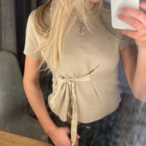 Beige kortärmad topp med knyt - Snygg beige topp med korta ärmar och knytband i midjan från zara. Använd fåtal gånger!