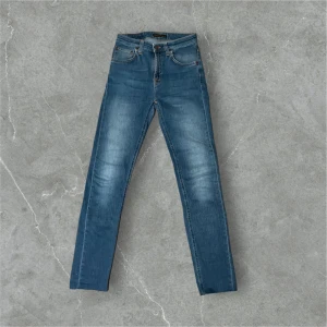Blå jeans från Nudie Jeans - Säljer dessa feta blå jeans från Nudie Jeans med klassisk femficksdesign och orange sömmar. Jeansen är i fint skick utan skador bara att dom är klippta där nere och passar dig som är mellan 175-185. Nypris ca 1300. Kontakta om frågor och pris kan diskuteras!🤩🙏