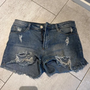 Låga jeanshorts - Snygga lågmidjade jeansshorts från Kendall & Kylie med slitna detaljer. Perfekta för sommaren och lätta att matcha med allt. Tyvärr lite små för mig därför jag säljer storlek 5/6 (US) men skulle säga att dom passar någon med 34 eller 36