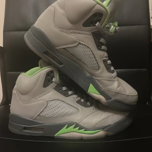 Nike Air Jordan 5 retro green bean - Använda men inte jätte slitna köpta från Nikes hemsida har kvitto för kostar  2249kr nya. Lyser i mörkret som en reflex väst storlek 42,5.