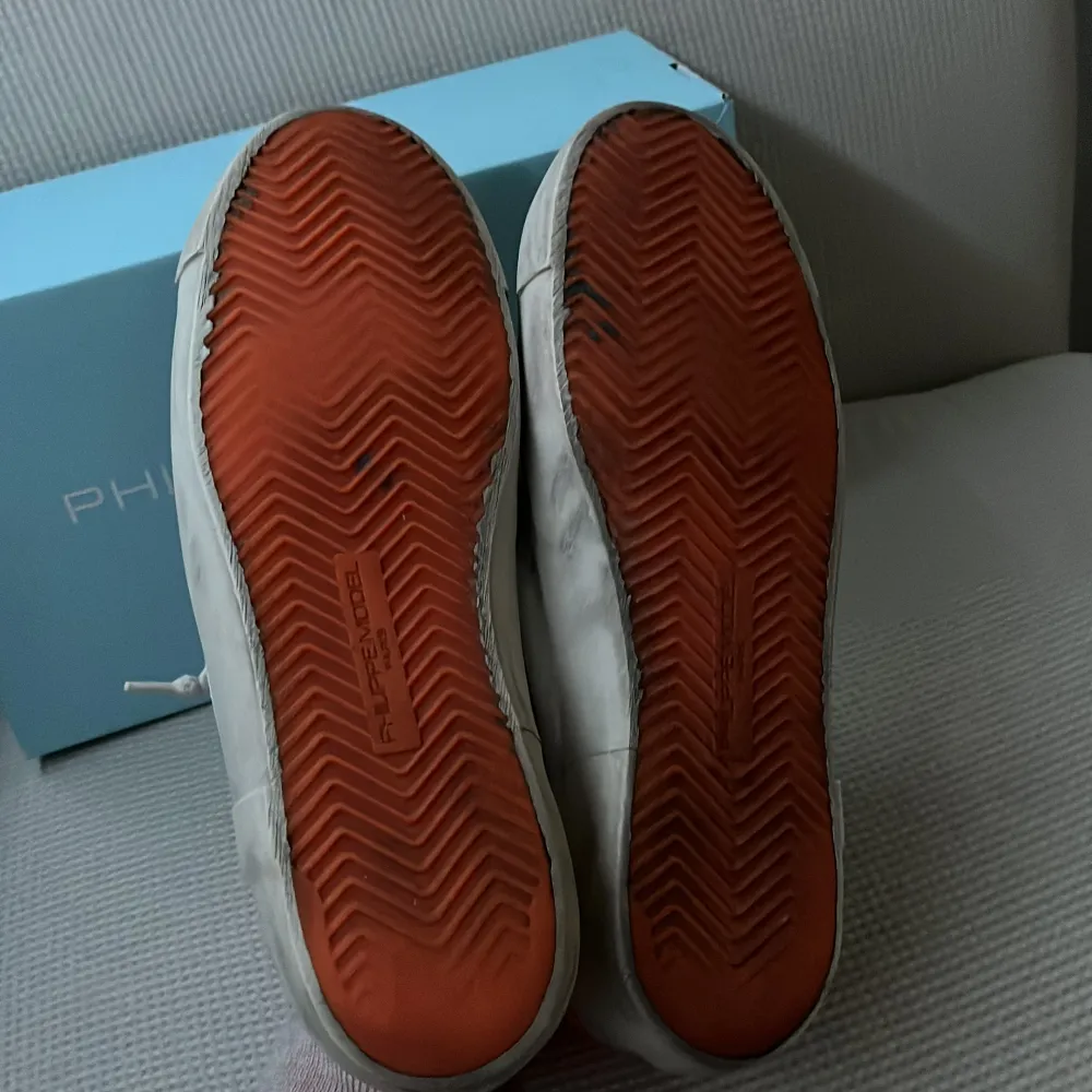 Snygga grå sneakers från Philippe Model med orange detaljer. Skorna har en rund tå och snörning framtill. Tillverkade i skinn med en cool, sliten look. Perfekta för en avslappnad stil.. Kengät.