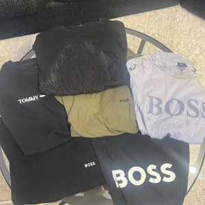 T-shirtar från Boss och Tommy Hilfiger - Säljer en samling av t-shirtar från Boss och Tommy Hilfiger. Färgerna inkluderar svart, grön och ljusblå. T-shirtarna har korta ärmar och är tillverkade i bomull. Perfekta för en avslappnad stil. 300kr för alla