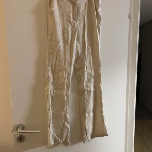 Beige linnebyxor - Säljer ett par stilrena beige linnebyxor. Byxorna är lågmidjade och är bootcut
