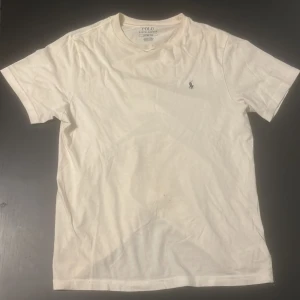 Vit t-shirt från Ralph Lauren - Säljer en klassisk vit t-shirt från Ralph Lauren. Tyvärr lite sliten i kragen. Det står storlek L(barn), men passar mig med strl S (170-180)