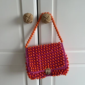 Färgglad axelväska med pärlor - Färgglad axelväska dekorerad med orange och rosa pärlor. I väldigt bra skick. 