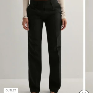 Svarta kostymbyxor - Svarta lågmidjade kostymbyxor från Nelly aldrig använda, lappen sitter fortfarande på. Säljer då det är för små för mig.