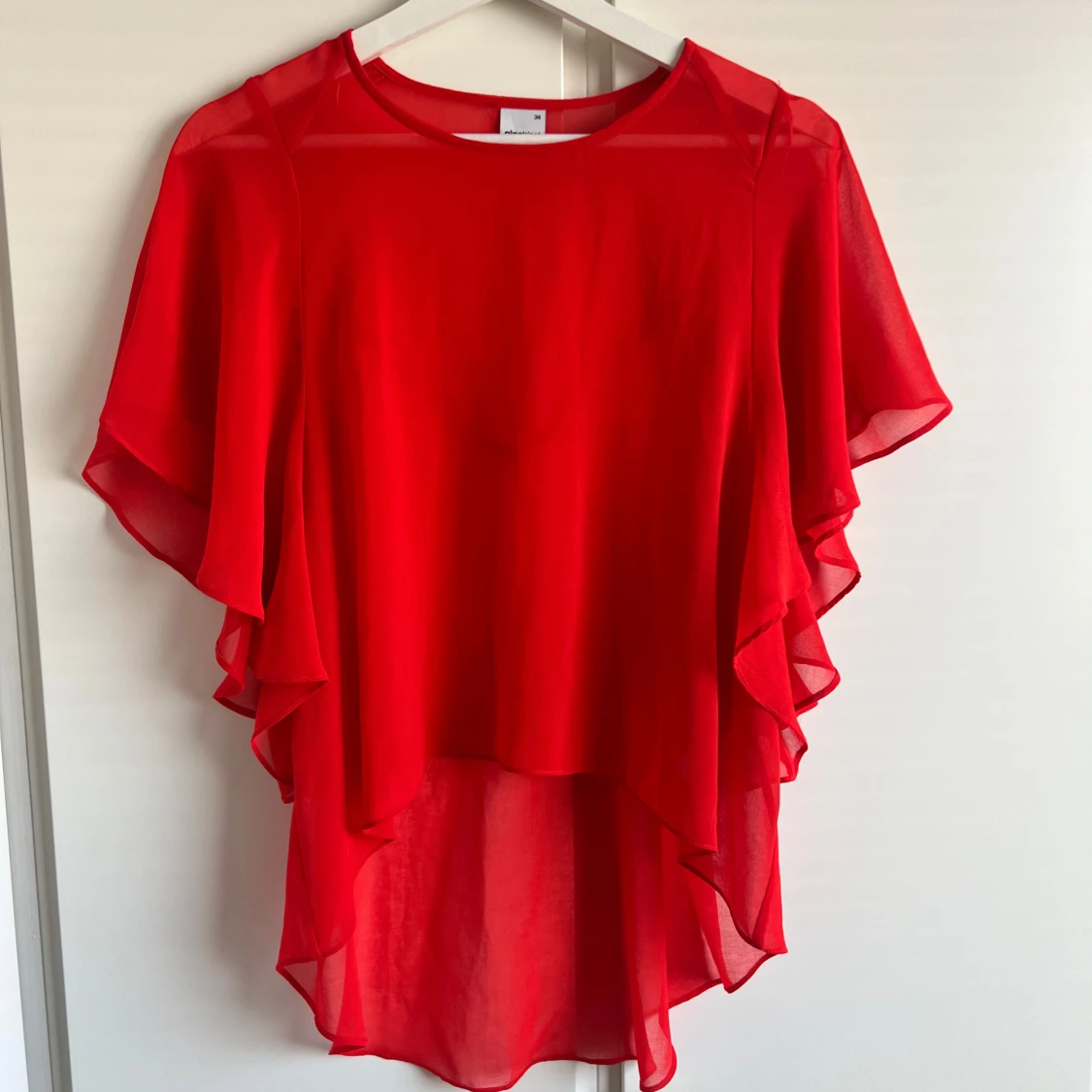 Röd blus med volangdetaljer