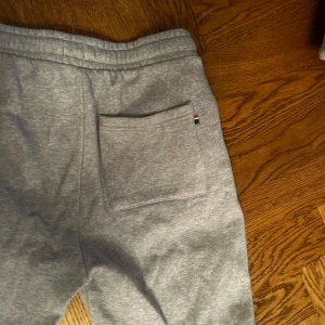 Grå mjukisbyxor från U.S. Polo Sport - Säljer ett par grå mjukisbyxor från U.S. Polo Assn. med elastisk midja och fickor. Perfekta för en avslappnad stil. Byxorna har en liten logga på sidan och är gjorda i mjukt material för extra komfort.