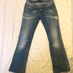 Blå jeans med broderade bakfickor - Snygga blå lågmidjade jeans från Miss Sixty med unika broderade detaljer på bakfickorna. 