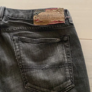 Mörkgrå jeans från Ralph Lauren - Snygga svarta jeans från Ralph Lauren med en klassisk femficksdesign. De har en diskret tvättad look och en patch med logotypen på baksidan. Perfekta för en stilren vardagslook.