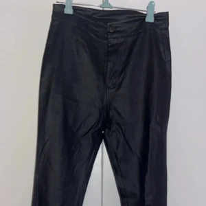 Svarta byxor från Shein - Snygga svarta byxor från Shein i en slim passform. Byxorna har en glansig finish som ger en cool look. Perfekta för att styla upp din outfit med en edgy touch.