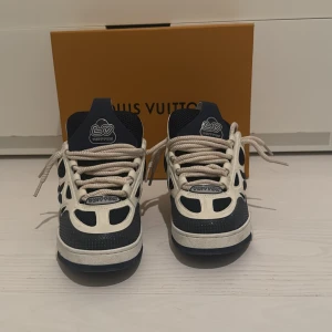 Blå och vita Louis Vuitton skates  - Snygga sneakers från Louis Vuitton i blått och vitt med unika detaljer och snörning, modell LV skates. Skorna har en rund tå och en stilren design med märkets ikoniska blommönster på sidan. Skick 9/10 inget tecken på användning. Låda, dustbags och kvitto ingår. 