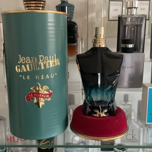 Jean Paul Gaultier Le Beau Le Parfum - Säljer en elegant parfym från Jean Paul Gaultier, Le Beau Le Parfum. Flaskan har en unik design i form av en manlig torso i svart och blått glas, med en guldig spraytopp. Förpackningen är en stilren grön cylinder med guldtext. Perfekt för den som vill ha en distinkt och lyxig doft. Köpt för 1615 kr🤩😀🤩det är kanske 20 till 25 ml kvar avgör själv!!