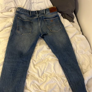 Blå jeansbyxor från Armani - Snygga blå jeansbyxor från armani med klassisk femficksdesign och knappgylf. Perfekta för en avslappnad stil.