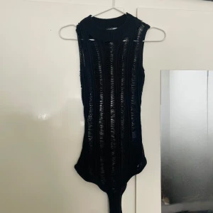  bodysuit från Fashion Nova -  svart ärmlös bodysuit från Fashion Nova med ribbad design och knäppning i grenen. 
