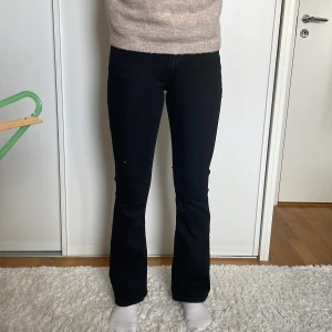 Svarta jeans från Gina - Snygga svarta jeans från Gina med en klassisk design. De har en boot cut modell och är Lågmidjade. De är perfekta för en stilren look. Jeansen har fickor både fram och bak.