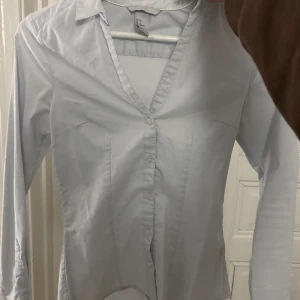 Ljusblå figurnära skjorta - Supersnygg ljusblå skjorta från H&M (men köpt second hand). Sitter väldigt fint, figurnära och långa armar! Säljer då den är lite tajt på mig tyvärr:( 💗