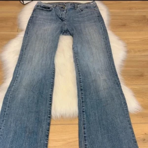 Bootcut jeans - Snygga blå jeans med en klassisk look och broderade detaljer på bakfickorna. De har en rak passform och är perfekta för en avslappnad stil. Midjan är normalhög och de har en traditionell dragkedja och knapp framtill.