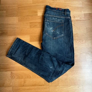 Mörkblå jeans från Dondup - Säljer nu mina mörkblåa Dondup jeans med slitningar. Det är den nya modellen av george strl 34! Skicket är 8/10 och nypris ligger på 3599! Hör av dig vid frågor/bilder! Modell George
