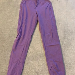 Lila mjukisbyxor - Säljer ett par lila mjukisbyxor med elastisk midja och muddar vid bensluten. Perfekta för en avslappnad stil.