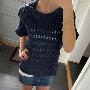 Blå stickad tröja  - Mörkblå glittrig stickad tröja/topp med krage som viks ner. Märket är Yessica men kan inte hitta storlek, skulle säga S/M. Lite nopprig men annars fint skick. Använd gärna köp nu!