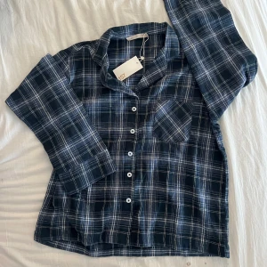 Pyjamasskjorta i flanell - Helt ny Snygg blå rutig pyjamasskjorta med långa ärmar och knappar framtill. Perfekt för en avslappnad kväll. Men funkar såklart att använda ute på dagen också, pris kan diskuteras🤗