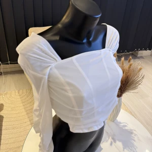 Vit offshoulder topp - Säljer en elegant vit offshoulder topp med långa ärmar och en stilren design. Toppen har en smickrande passform och är perfekt för en stilfull look. Passar perfekt i s/m storlek. Jag rekommenderar den varmt.🌸👌
