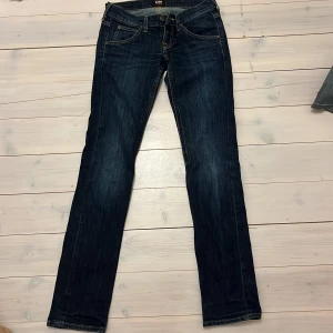 Mörkblå jeans från Lee - Snygga mörkblå low waist jeans från Lee med en straight pass form. De har aldrig använts och har inga defekter! 