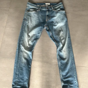 Blå jeans från Tiger of Sweden - Snygga blå jeans från Tiger of Sweden med en klassisk femficksdesign. De har en slim fit passform och är tillverkade i jeansmaterial. Perfekta för en stilren look. Storlek W30/L30. Köpte jeansen för 1500 och hade dom i 2 dagar och jag har så mycket andra jeans så det va dags att sälja dom