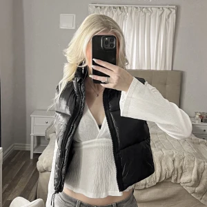 Svart dunväst från Zara - Snygg svart dunväst från Zara med dragkedja. Perfekt för lager-på-lager under kyliga dagar. Västen har en stilren design och är lätt att matcha med olika outfits. Varit en favorit i min garderob men är fortfarande i fantastiskt nyskick!💕